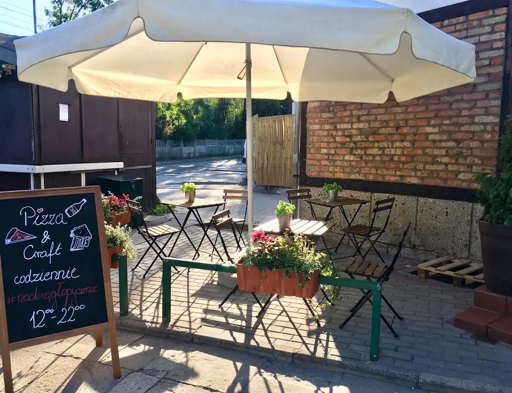 Ogródek ze stolikami pod białym parasolem